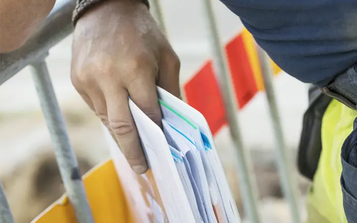 Närbild på hand som håller en mapp med papper