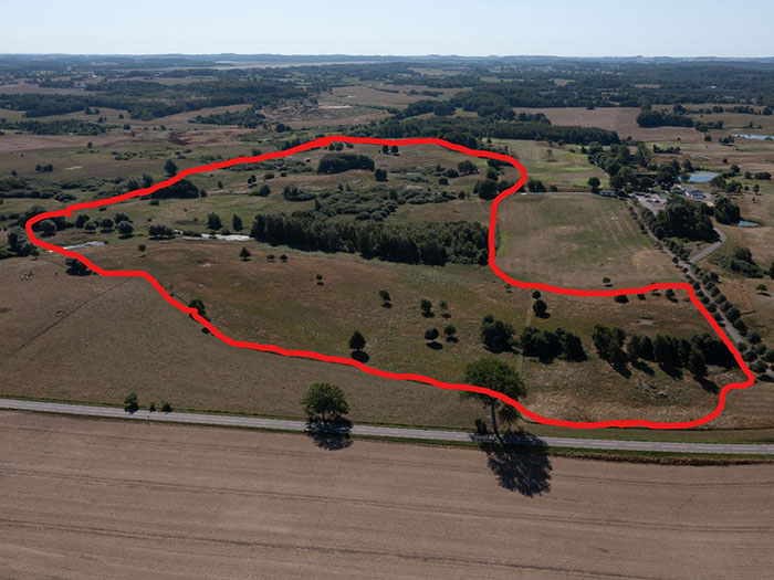 Drönarvy över golfbana med röd markering för tänk solpark.