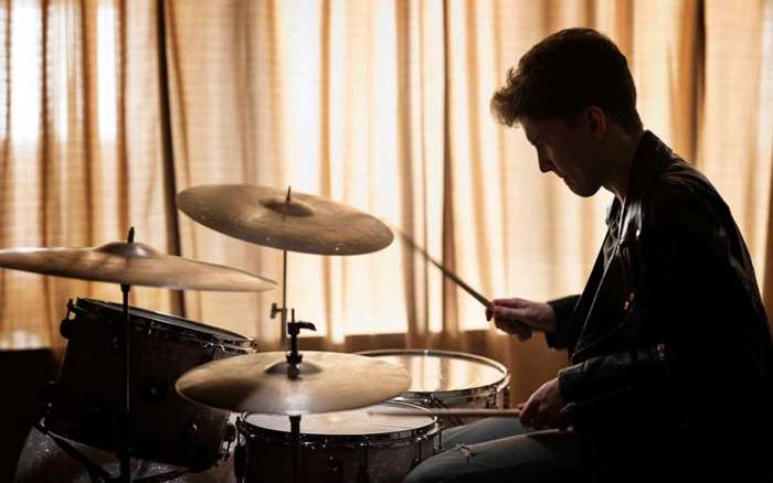 Ung man spelar trummor